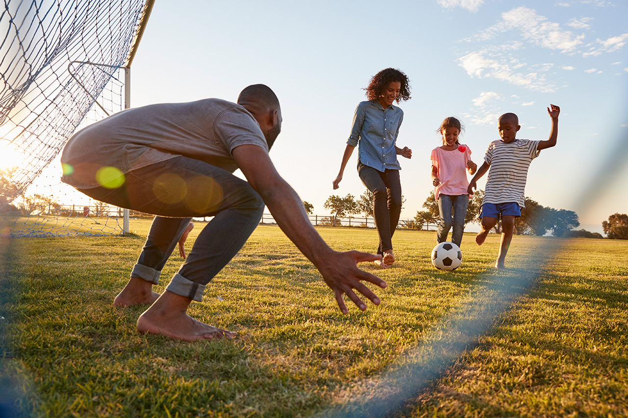 /a-boy-kicks-a-football-during-a-game-with-his-family