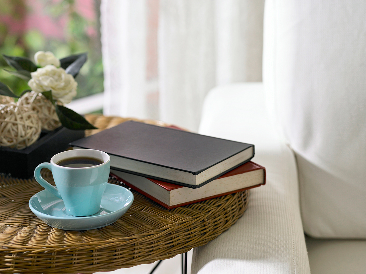 Books on a table next to a coffee cup